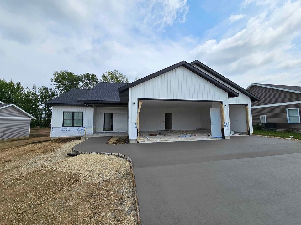 A house is being built with a large garage and a driveway.