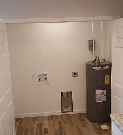 A laundry room with a water heater and a sink.