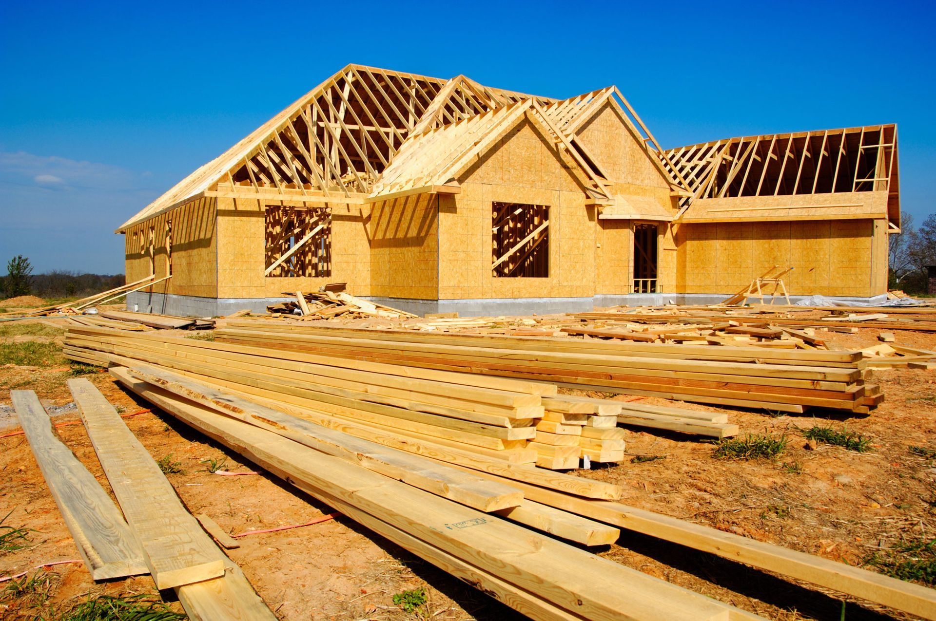 A house is being built with a lot of wood in front of it