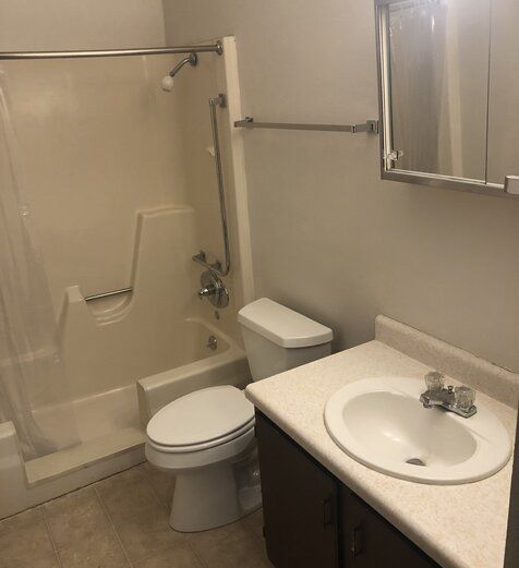 A bathroom with a toilet a sink and a bathtub