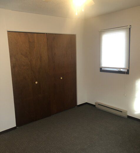 An empty room with a window and a closet