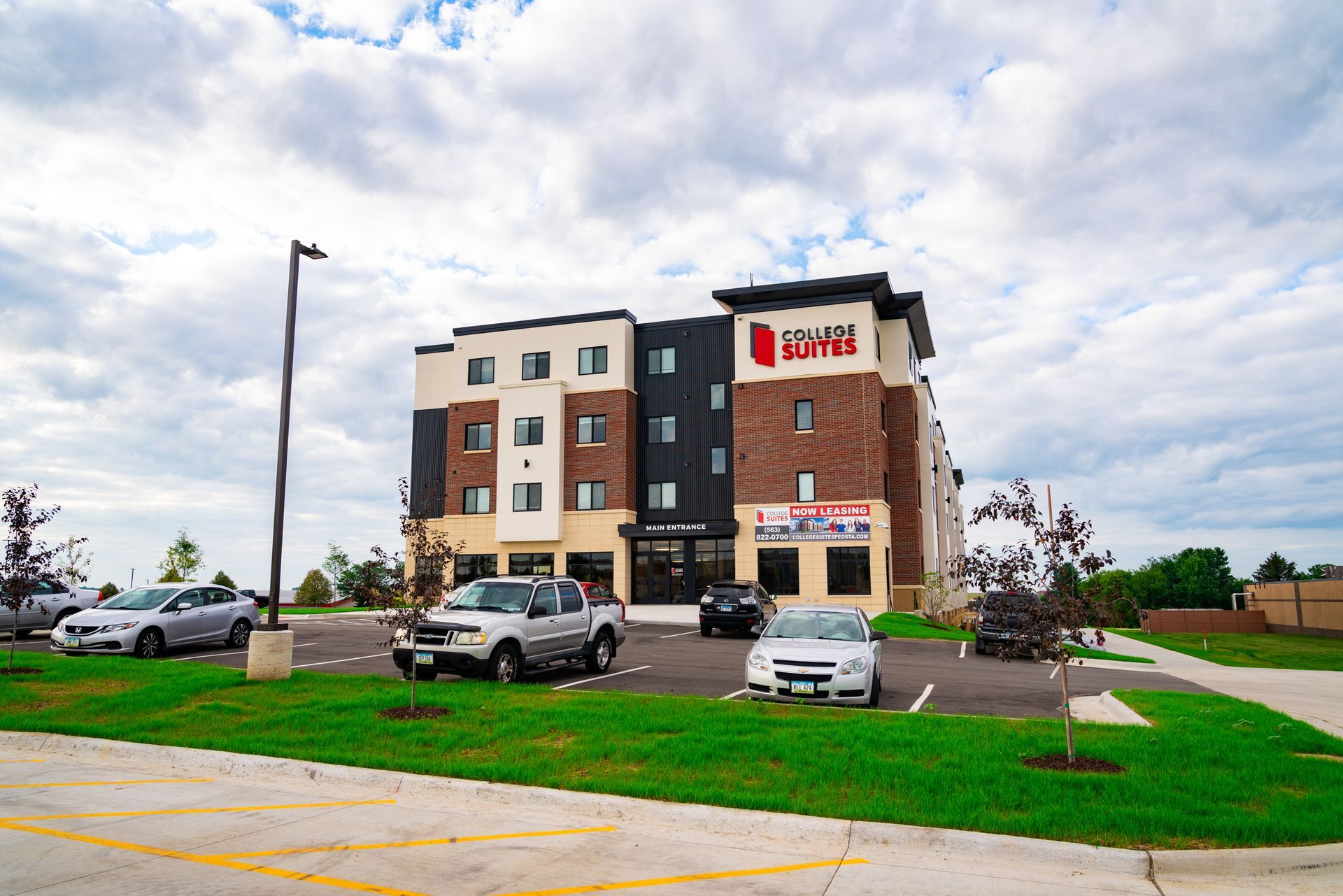 A large building with a lot of cars parked in front of it.