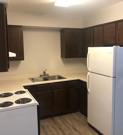 A kitchen with a refrigerator stove and sink