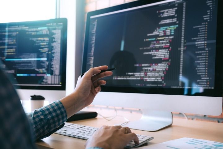 A man is sitting at a desk working on a computer.