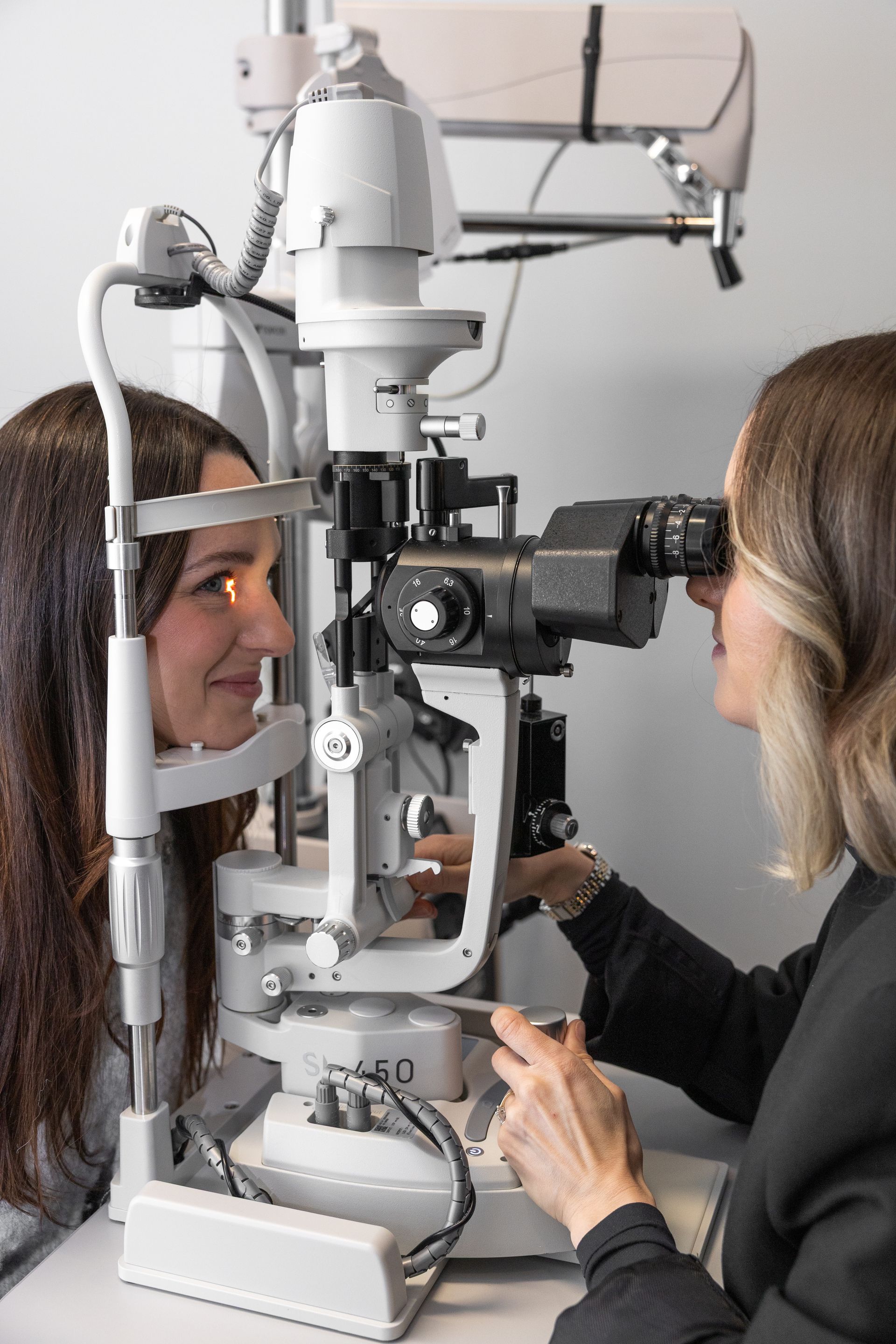 Eye doctor examines a patient with a slit lamp in a clinic