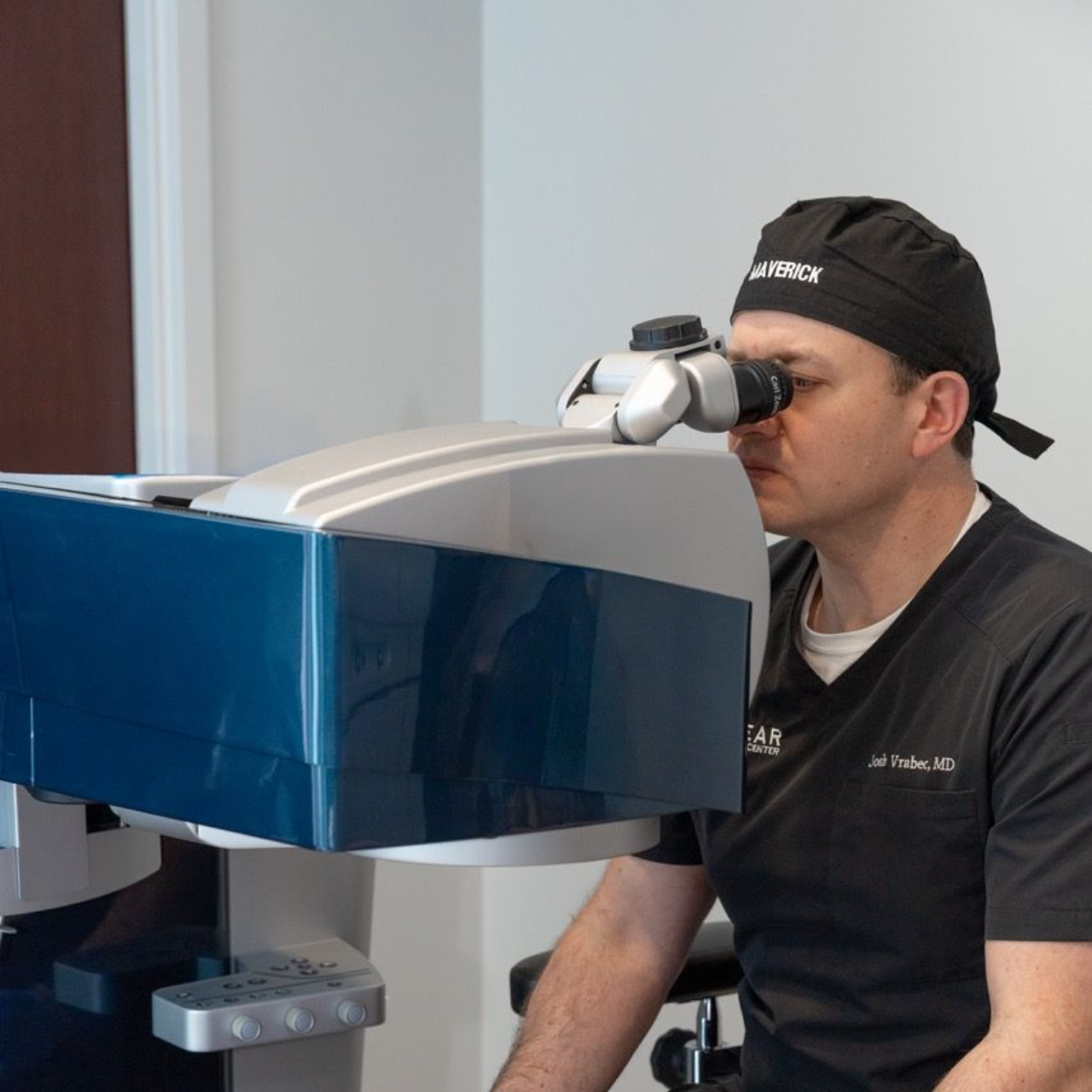 Technician using a diagnostic eye scanner in a clinical setting