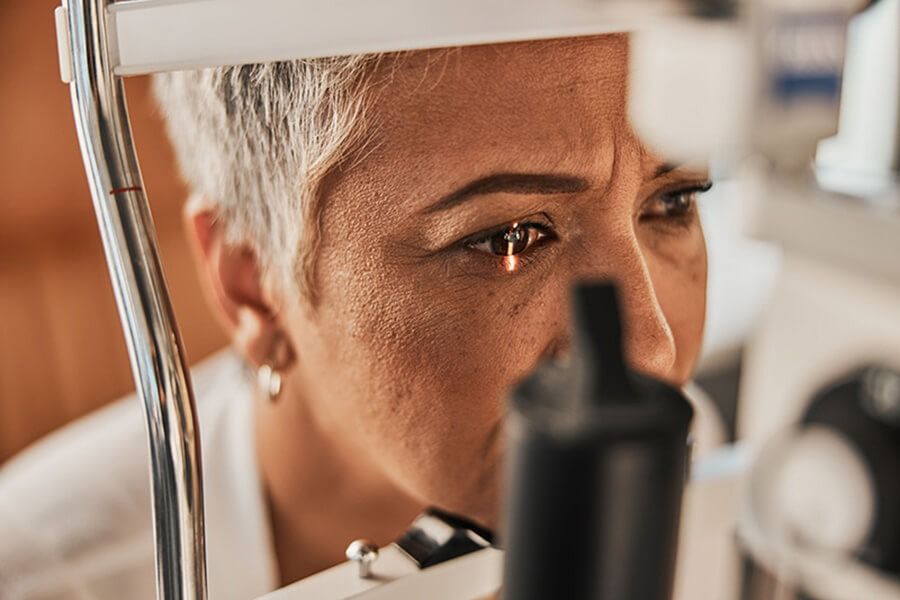 Close-up of a person looking through a microscope, focused and thoughtful in a lab setting