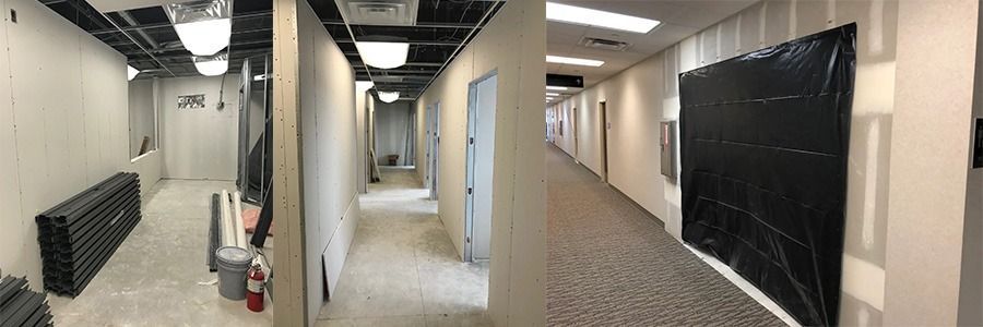 Renovated office hallway with exposed ceiling, carpet, and black plastic-covered wall panels