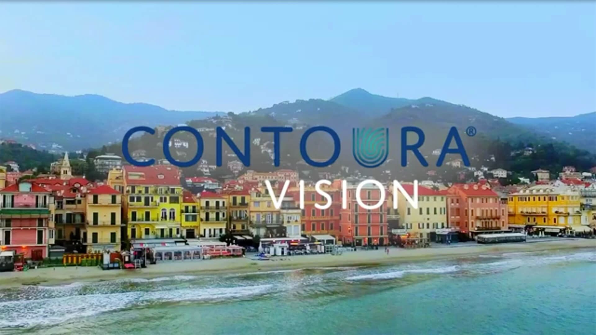 Colorful seaside town with mountains in the background and “CONTURA VISION” text overlay