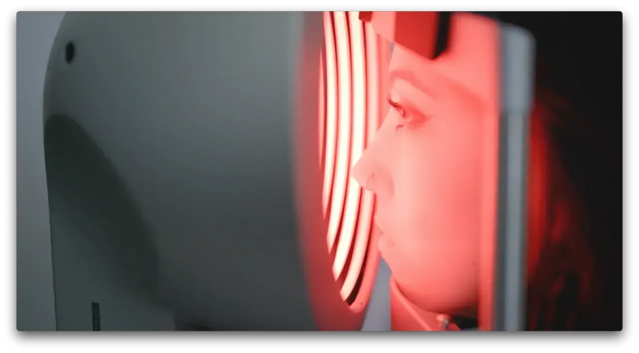 Person looking through a glowing red circular light in a dim room