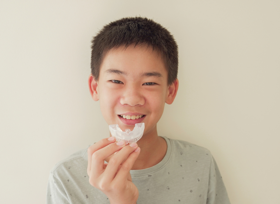 Colorful sports mouthguards stacked and laid out on a blue surface.