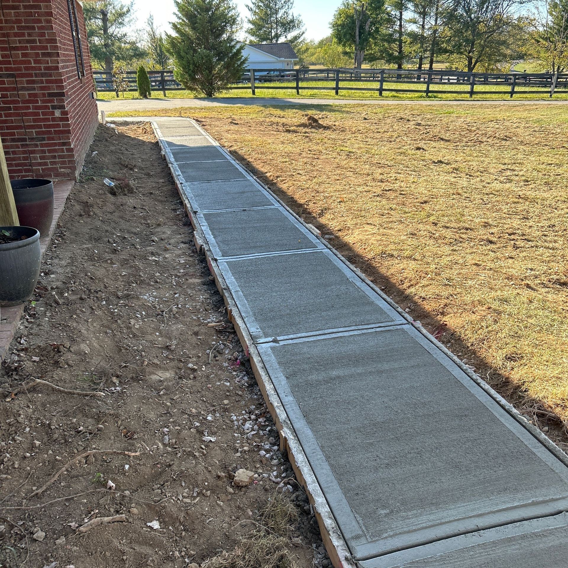 Nolan Construction removing and replacing concrete sidewalks, widened the flower bed and reclaimed yard in Richmond, KY.