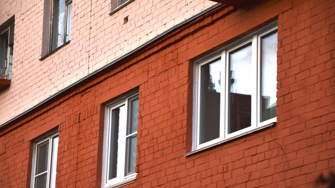 Red brick building with white-framed windows; the upper level is a lighter color.