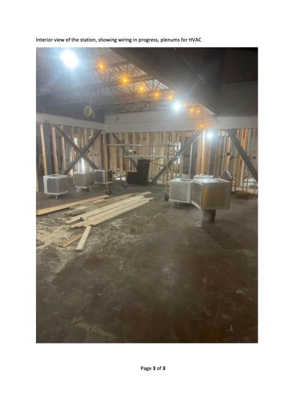 Interior of a building under construction, showing wooden framing and materials on the floor.