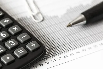 A calculator is sitting on top of a graph next to a pen