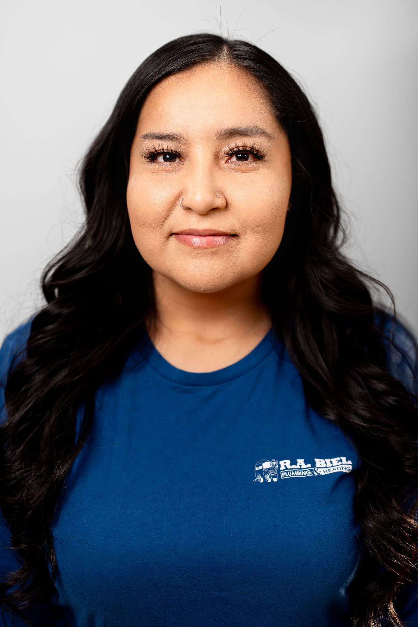 The woman is wearing a blue shirt and smiling for the camera.