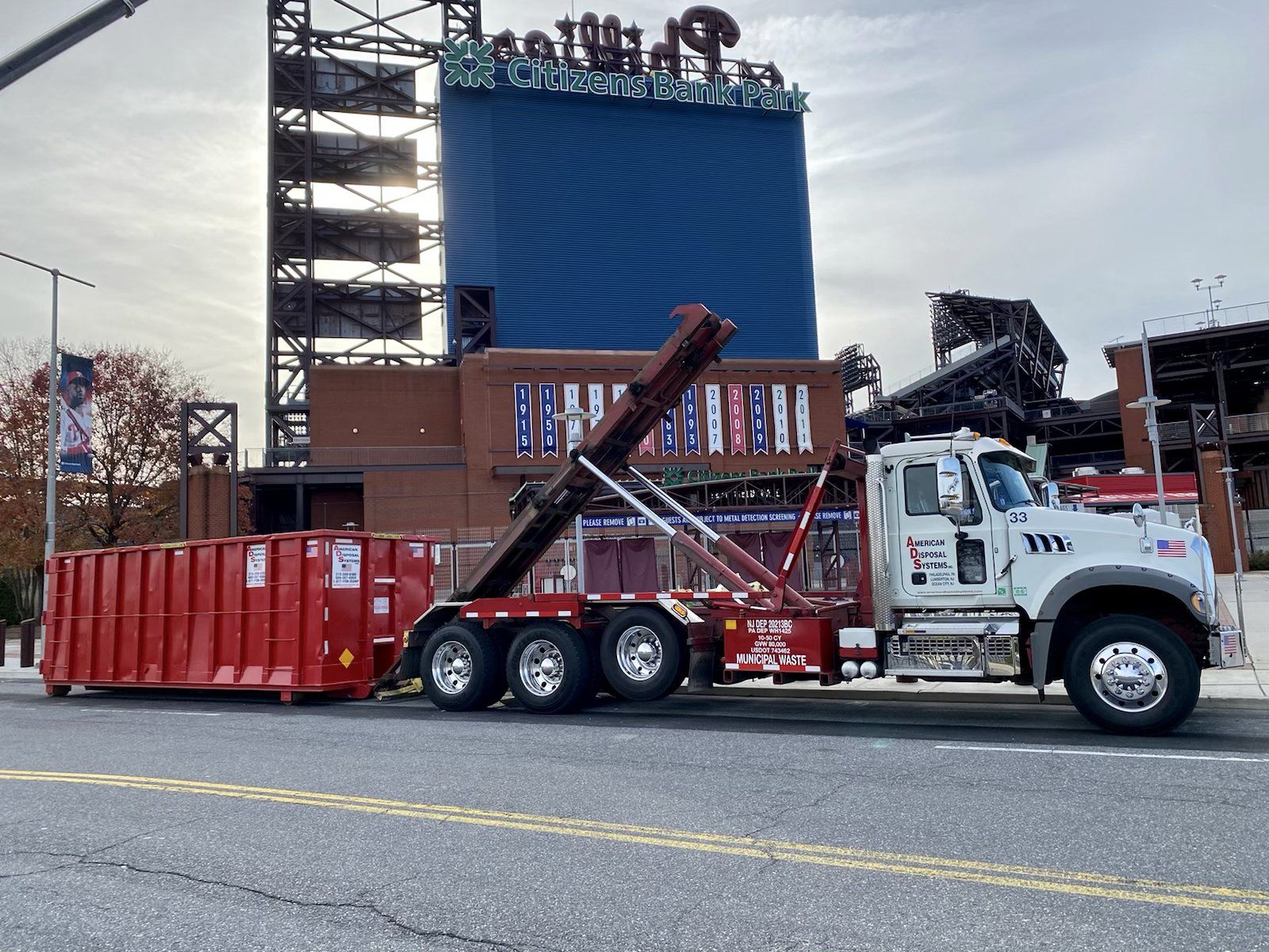 A dumpster truck is unloading a thirty cubic yard dumpster at Lincoln Financial Field