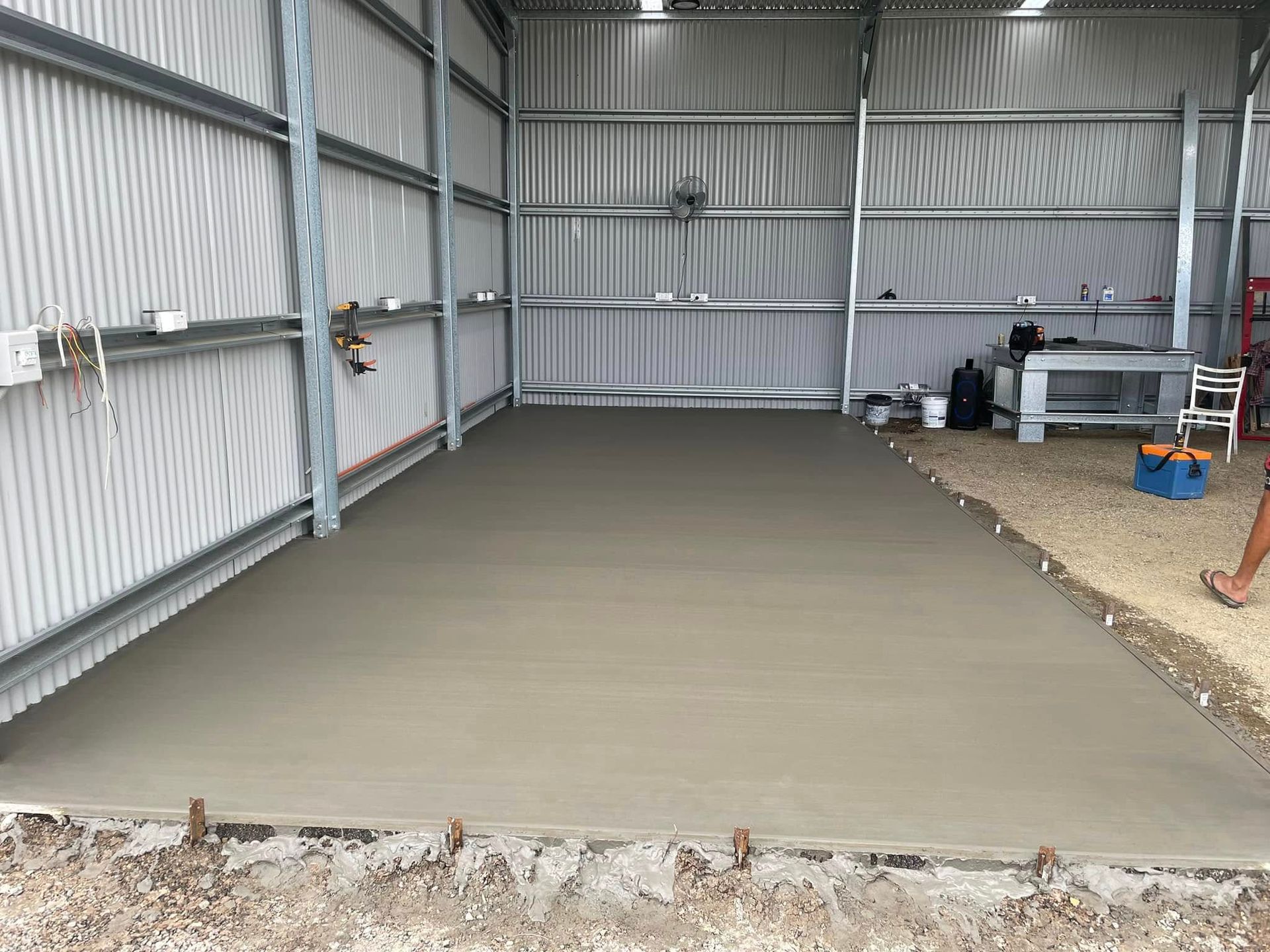 A man is standing in a garage with a concrete floor. — Upgrade Earthworks In South Kolan, QLD