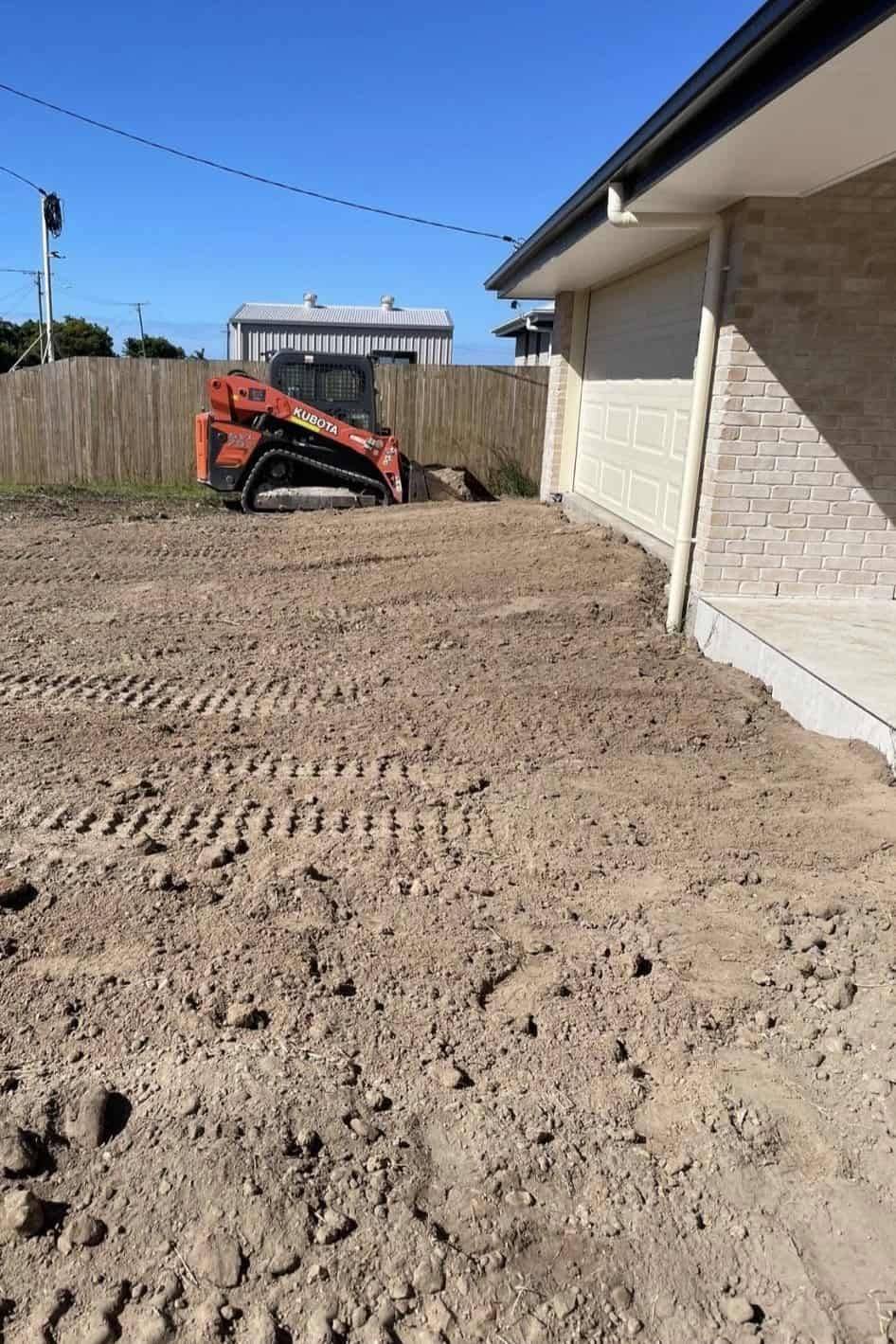A Bulldozer Is Moving Dirt In Front Of A House — Upgrade Earthworks In South Kolan, QLD