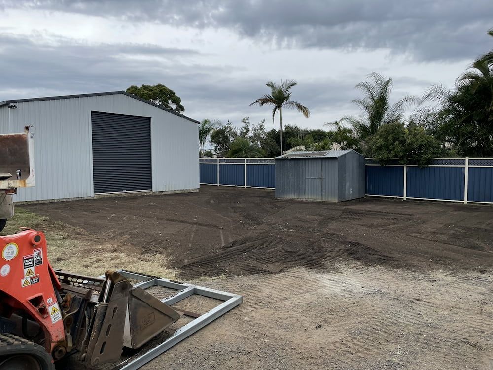 A Bulldozer Is Sitting In A Dirt Field In Front Of A Building — Upgrade Earthworks In South Kolan, QLD