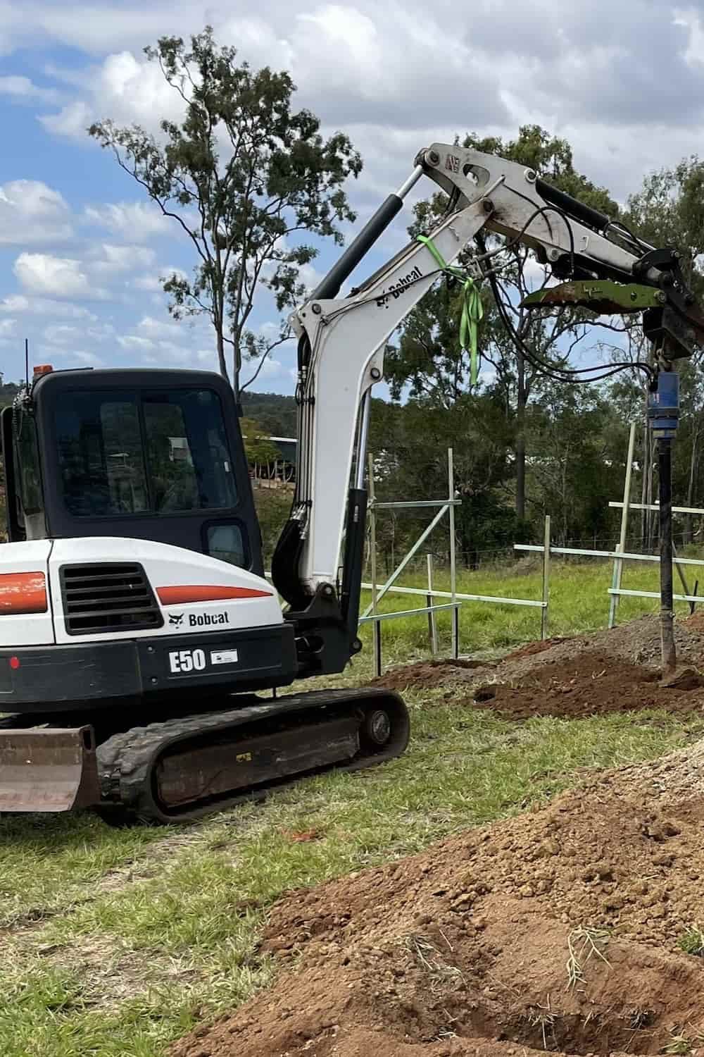 A Small Excavator Is Digging A Hole In The Ground — Upgrade Earthworks In South Kolan, QLD
