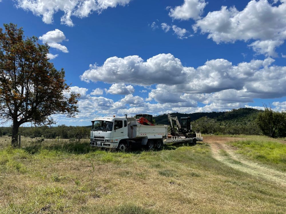 A Truck is Parked in the Middle of a Grassy Field — Upgrade Earthworks In South Kolan, QLD