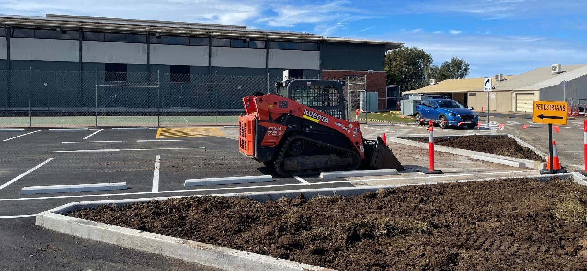 A bulldozer is digging a hole in a parking lot. — Upgrade Earthworks In South Kolan, QLD