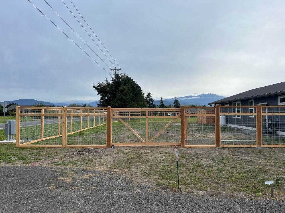 A wooden fence with a gate in front of a house.