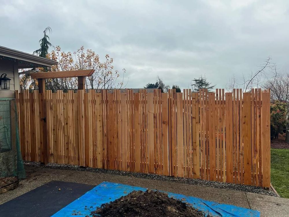 A wooden fence is sitting next to a pile of dirt.