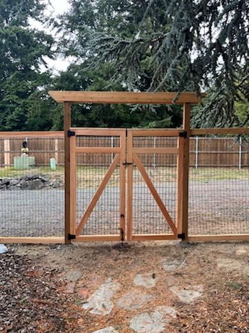 A wooden fence with a gate in the middle of it.