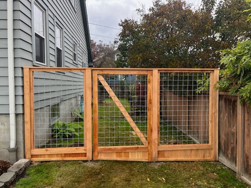 A wooden fence with a gate in the backyard of a house.