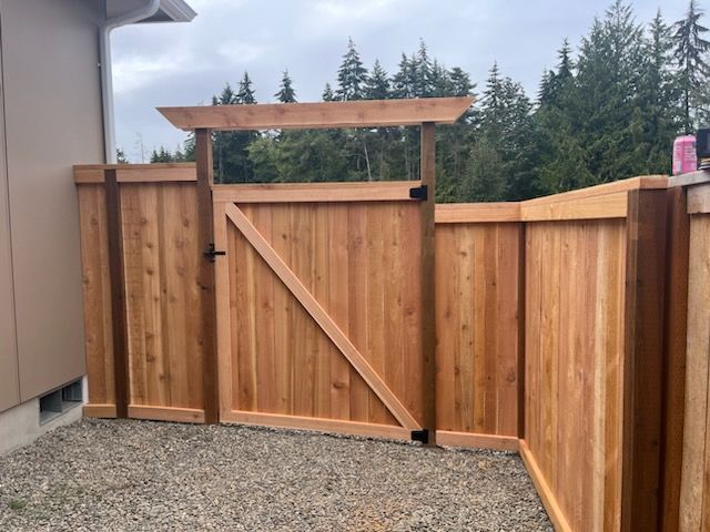 A wooden fence with a gate in the middle of it.