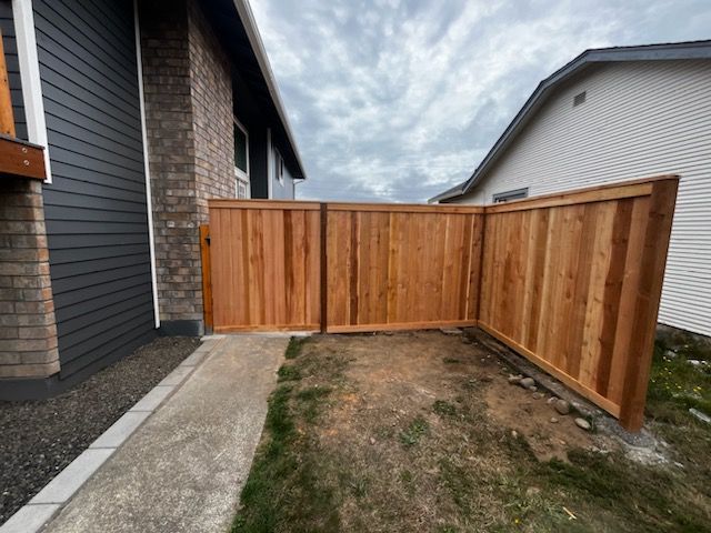 A wooden fence with a gate in front of a house
