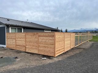 A wooden fence is sitting in front of a house.