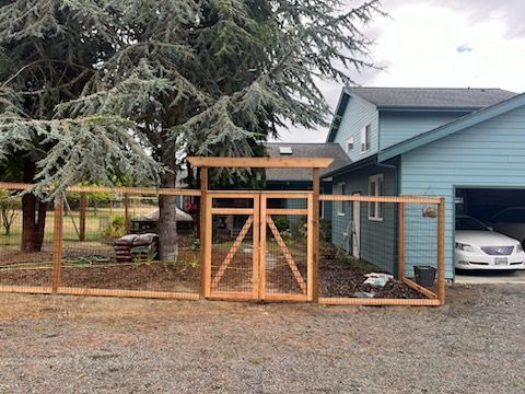 A wooden fence is being built in front of a house.