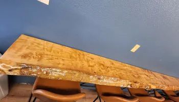A wooden table and chairs in a room with a blue wall.
