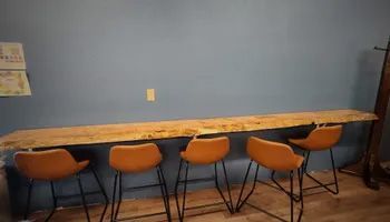 A room with a long wooden table and four chairs.