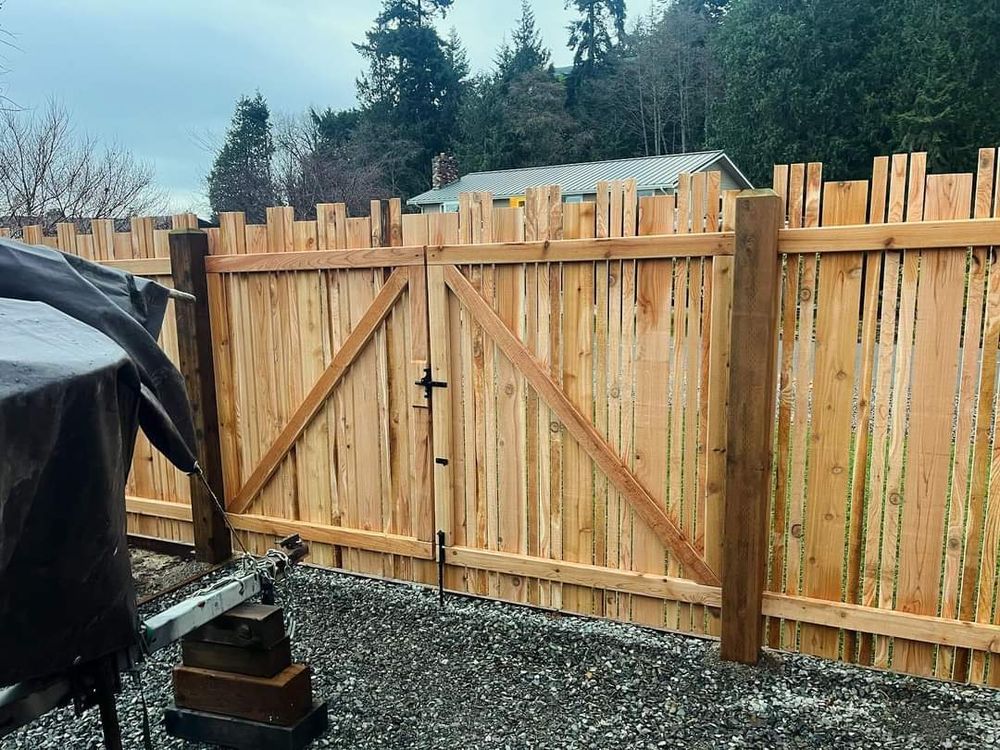 A wooden fence with a gate in the backyard.