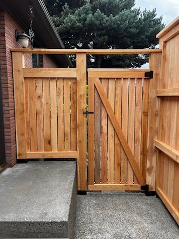 A wooden gate is sitting in front of a brick house.