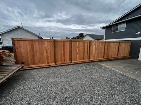 A large wooden fence is sitting in front of a house.