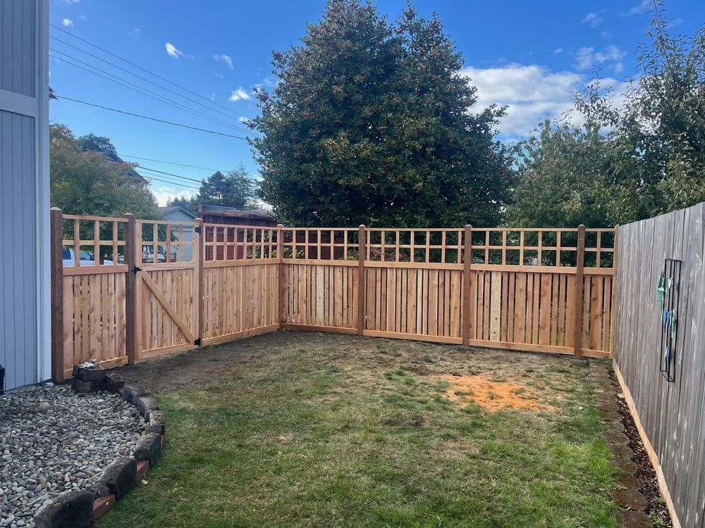 There is a wooden fence in the backyard of a house.
