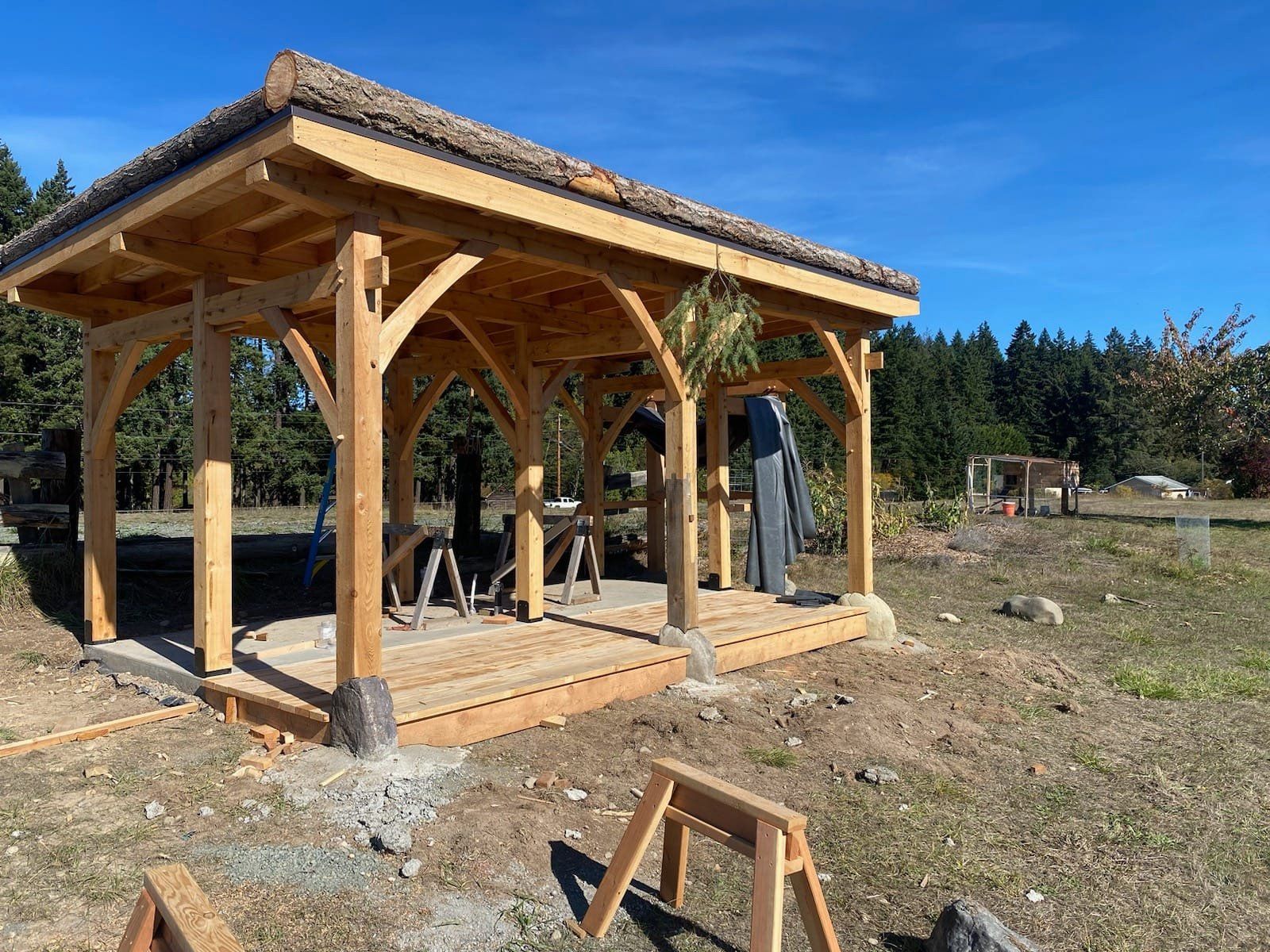 A wooden gazebo is being built in the middle of a field.