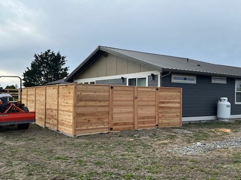 A wooden fence is sitting in front of a house.