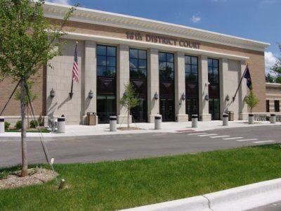 19th District Court building with flags, large windows, and manicured lawn.