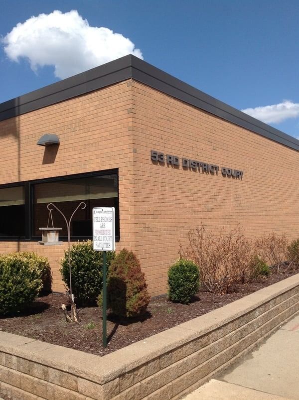 Exterior of the 55 RD District Court building, brick construction. Signage and landscaping present. Sunny day.