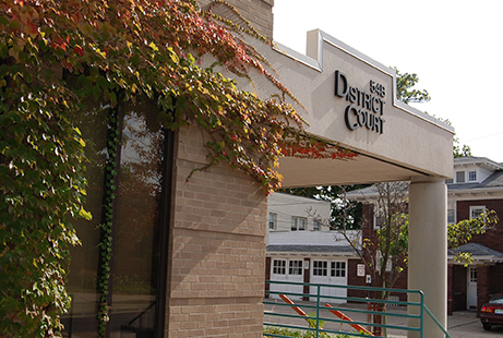 District Court entrance with ivy-covered brick wall and sign.