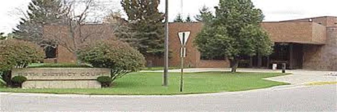 Sign for The Zimmerman College in front of a brick building.