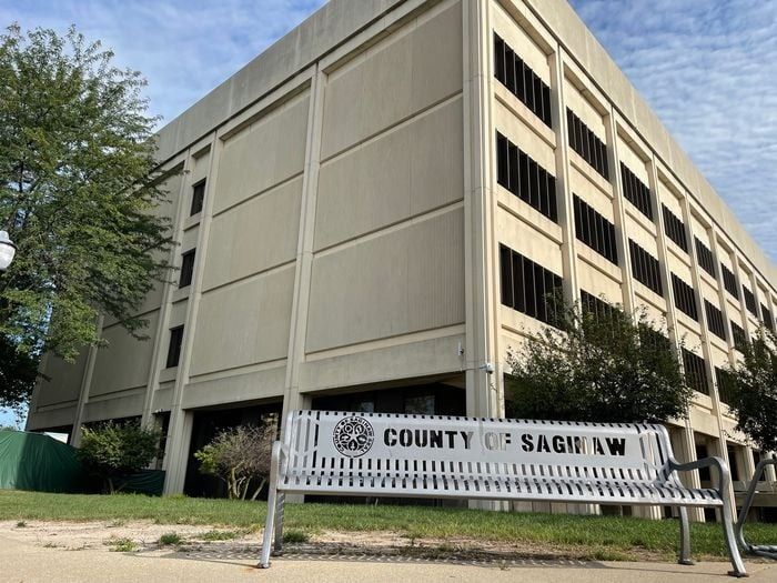 Exterior of the Saginaw County building with a bench.