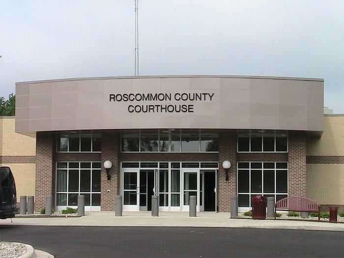 Roscommon County Courthouse building with a gray facade and brick accents.