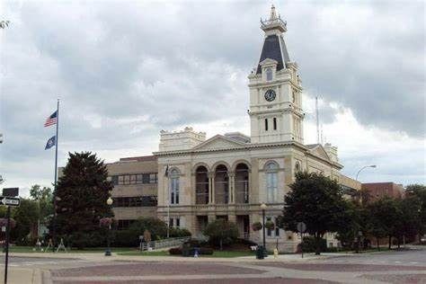 County courthouse building with clock tower under a cloudy sky.